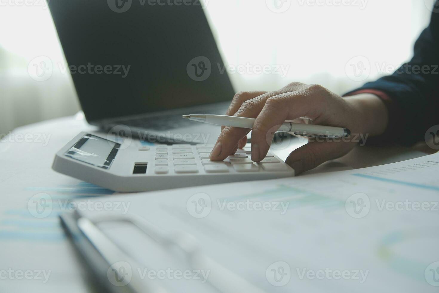 Unrecognizable businessman using calculator photo
