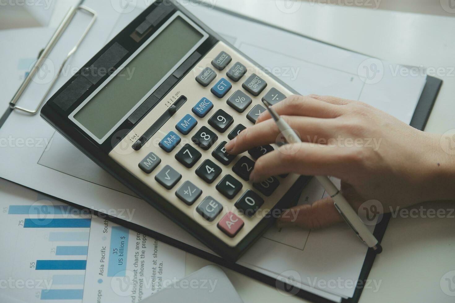 Unrecognizable businessman using calculator photo