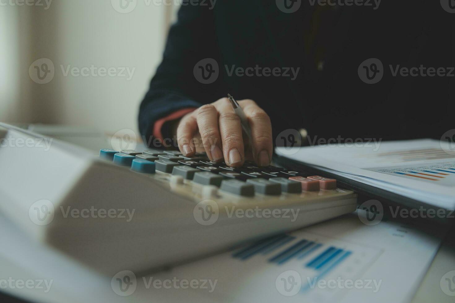 Unrecognizable businessman using calculator photo