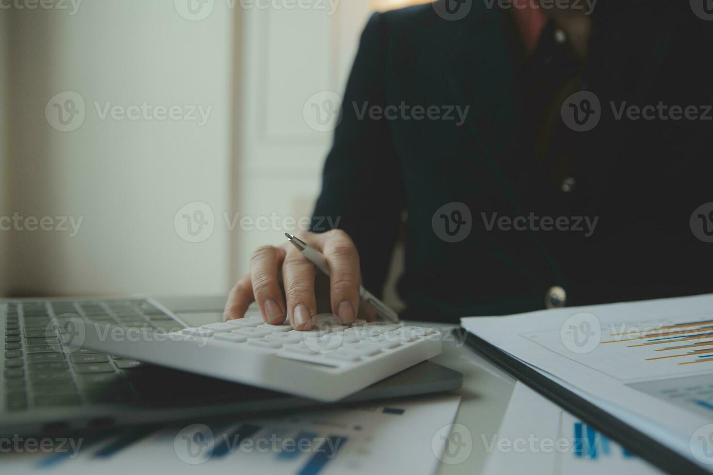Unrecognizable businessman using calculator photo