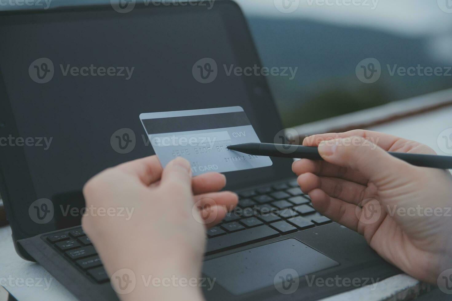 online payment, young woman holding credit card and typing on laptop photo