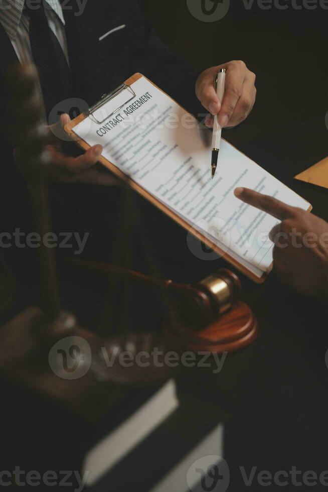 Business and lawyers discussing contract papers with brass scale on desk in office. Law, legal services, advice, justice and law concept picture with film grain effect photo