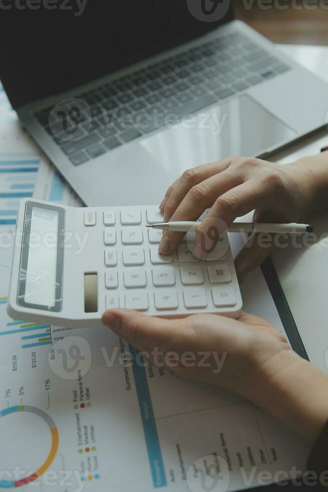 Unrecognizable businessman using calculator photo