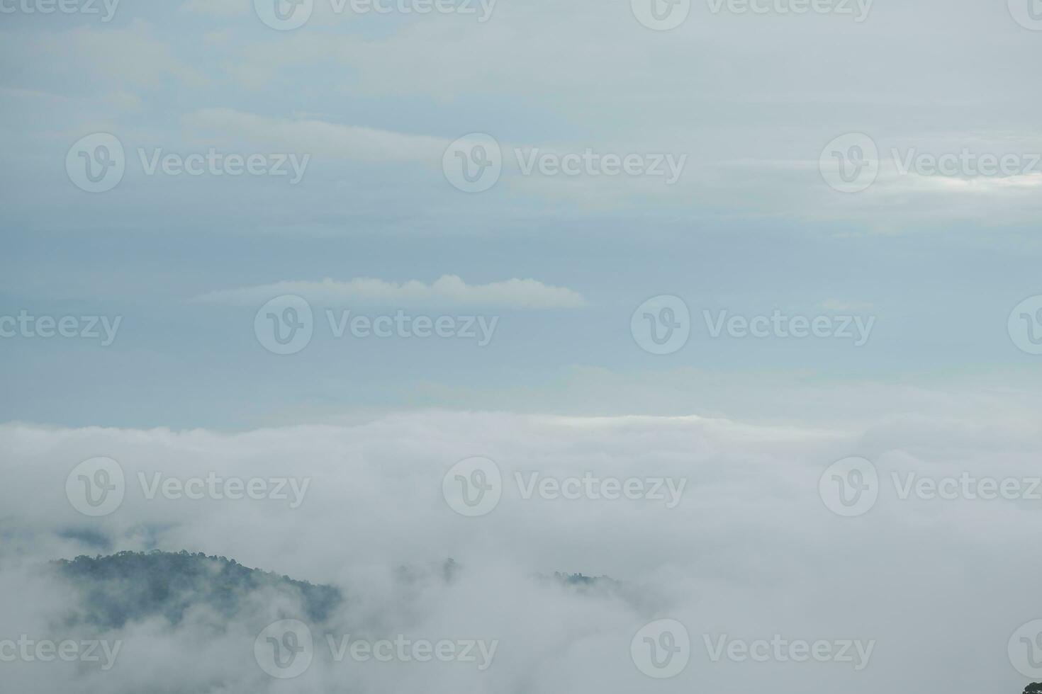 Mountain range with visible silhouettes through the morning blue fog. photo