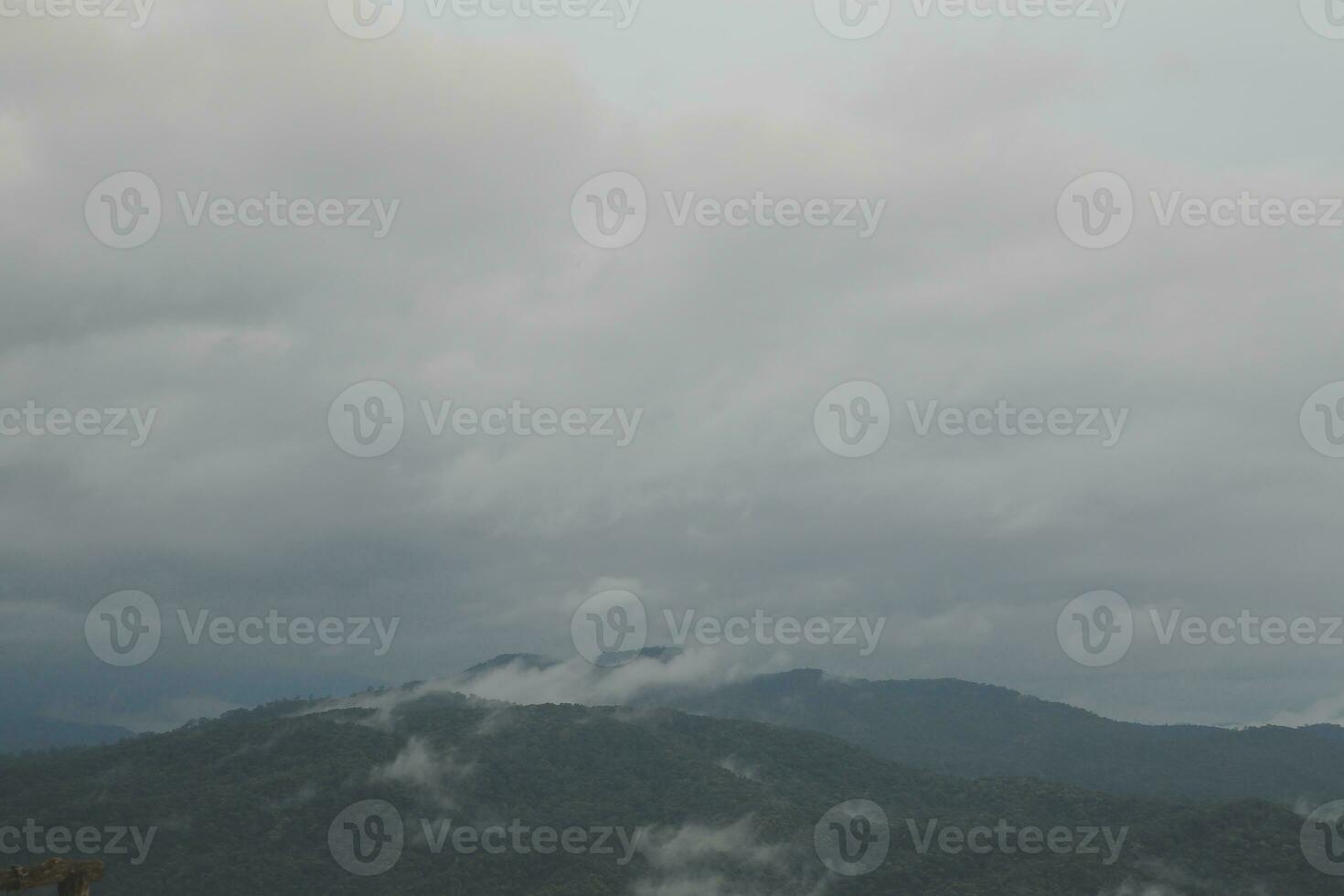 Mountain range with visible silhouettes through the morning blue fog. photo