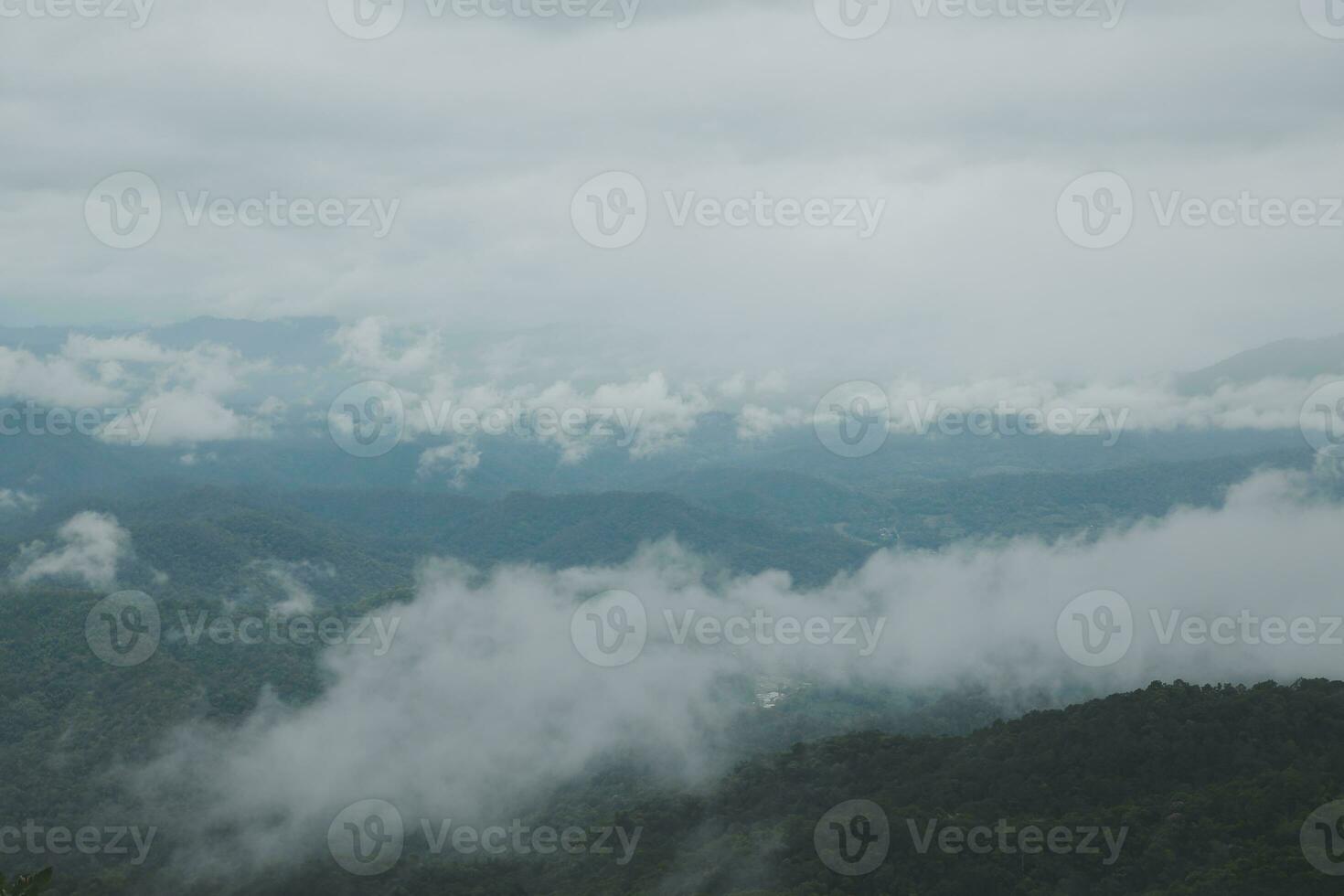 Beautiful panoramic view of fog and clouds in distant layers mountains range with blue sky in morning photo