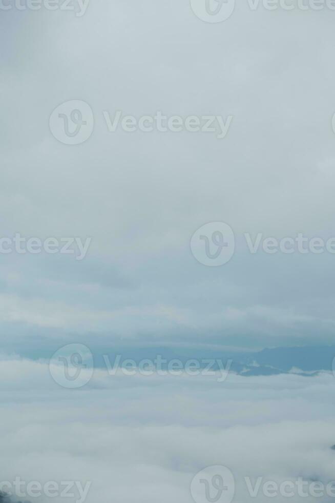 Mountain range with visible silhouettes through the morning blue fog. photo