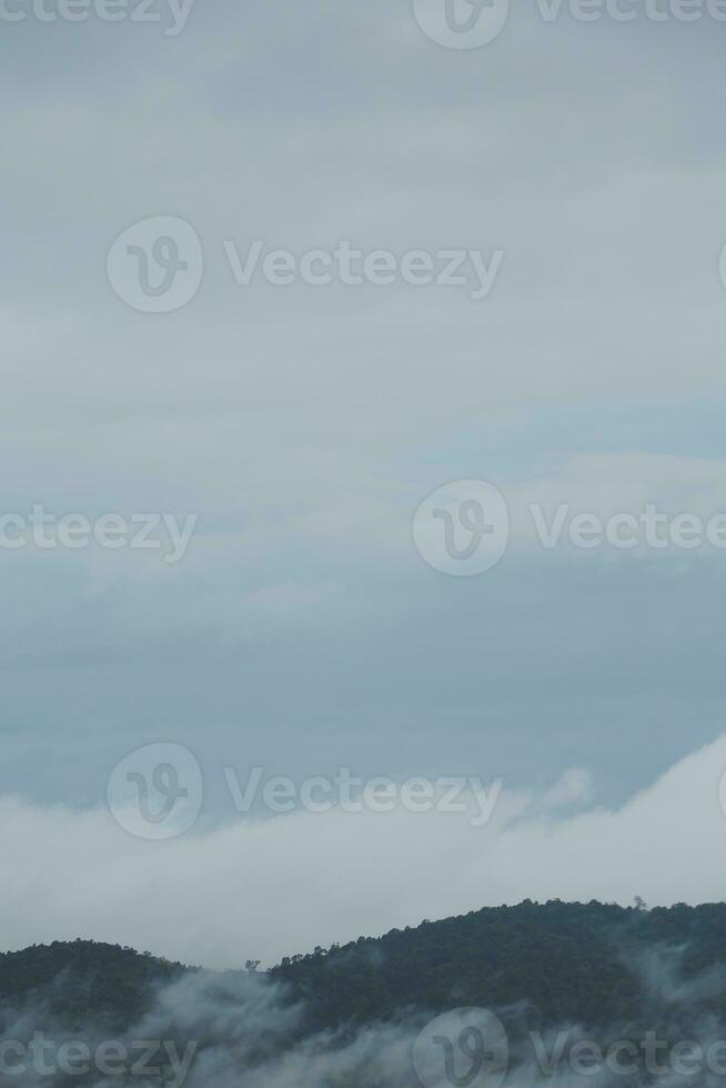 Mountain range with visible silhouettes through the morning blue fog. photo