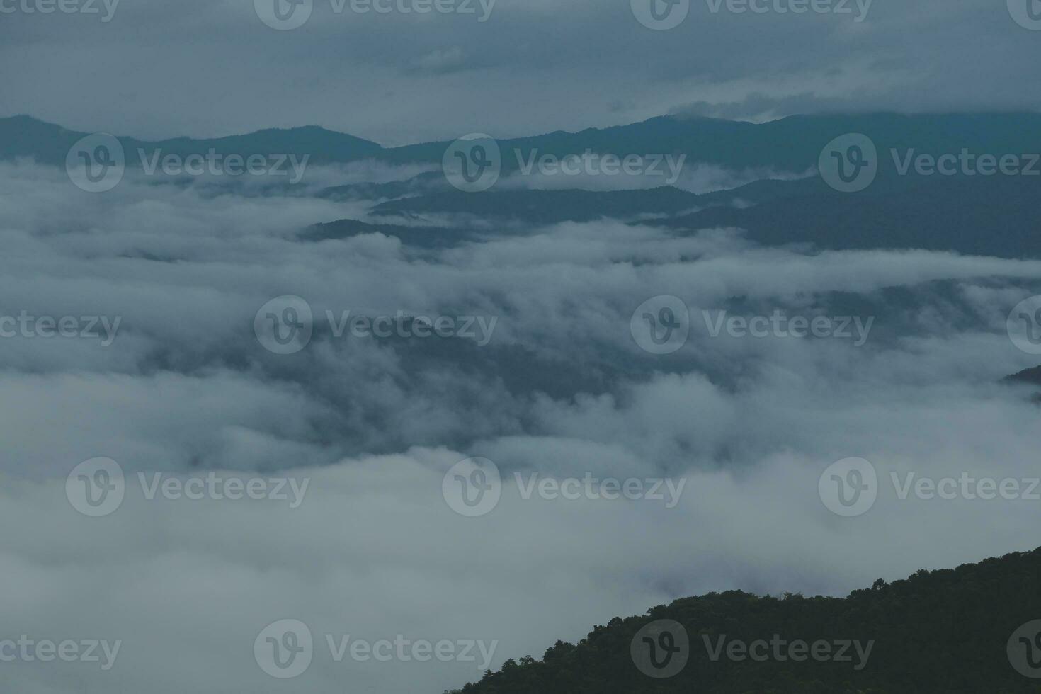 Mountain range with visible silhouettes through the morning blue fog. photo