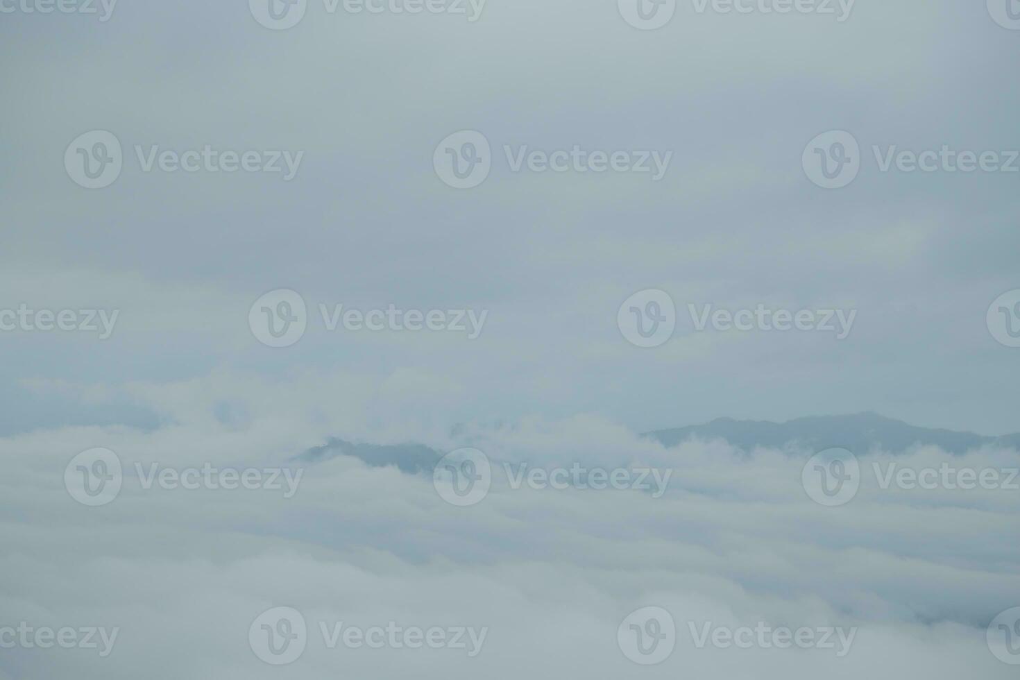 Mountain range with visible silhouettes through the morning blue fog. photo