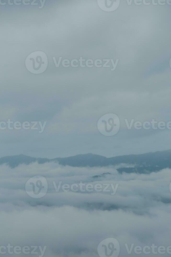 Mountain range with visible silhouettes through the morning blue fog. photo