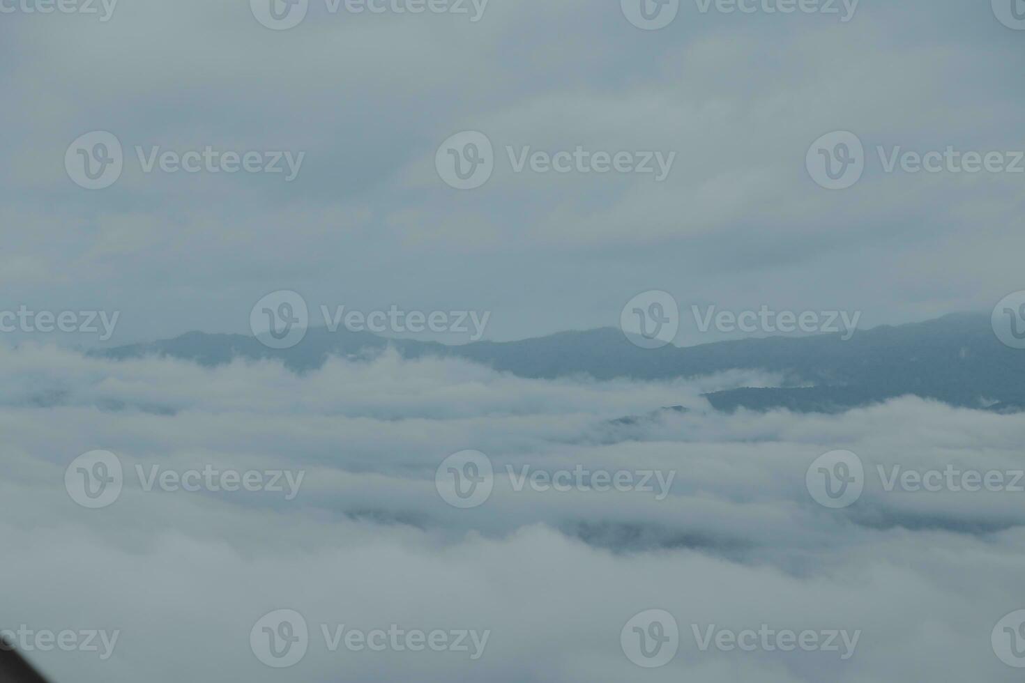Mountain range with visible silhouettes through the morning blue fog. photo
