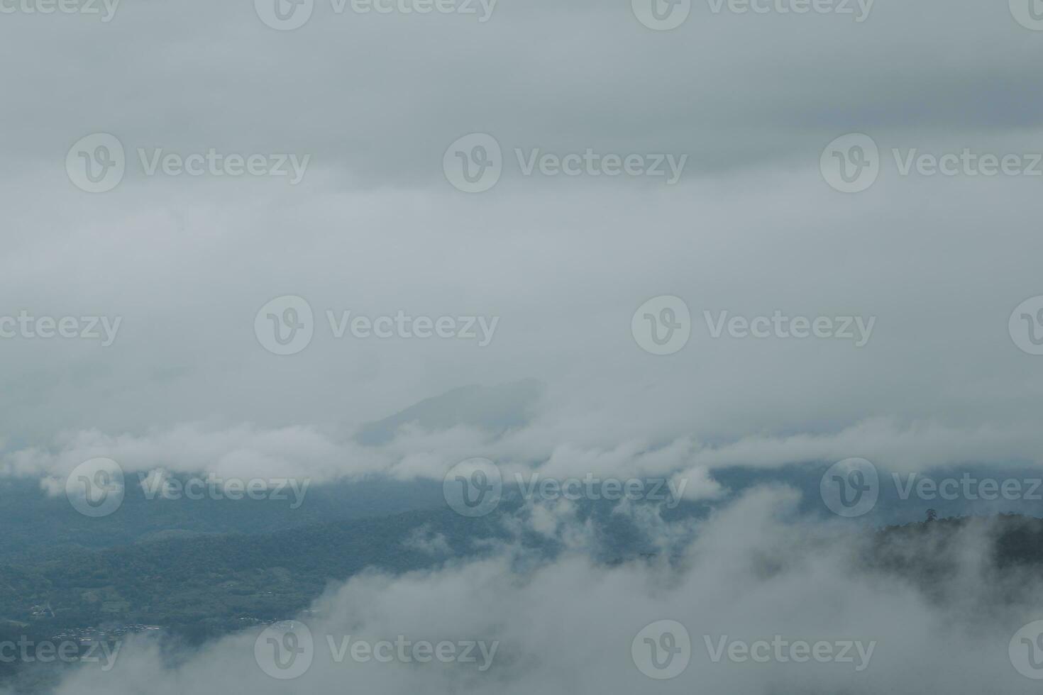 Beautiful panoramic view of fog and clouds in distant layers mountains range with blue sky in morning photo