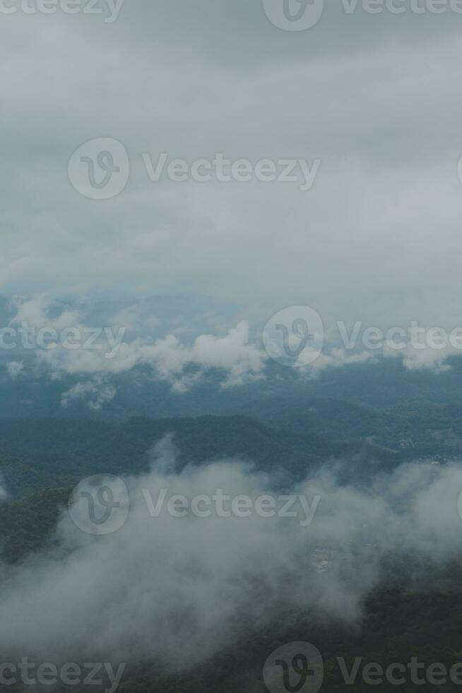 Beautiful panoramic view of fog and clouds in distant layers mountains range with blue sky in morning photo