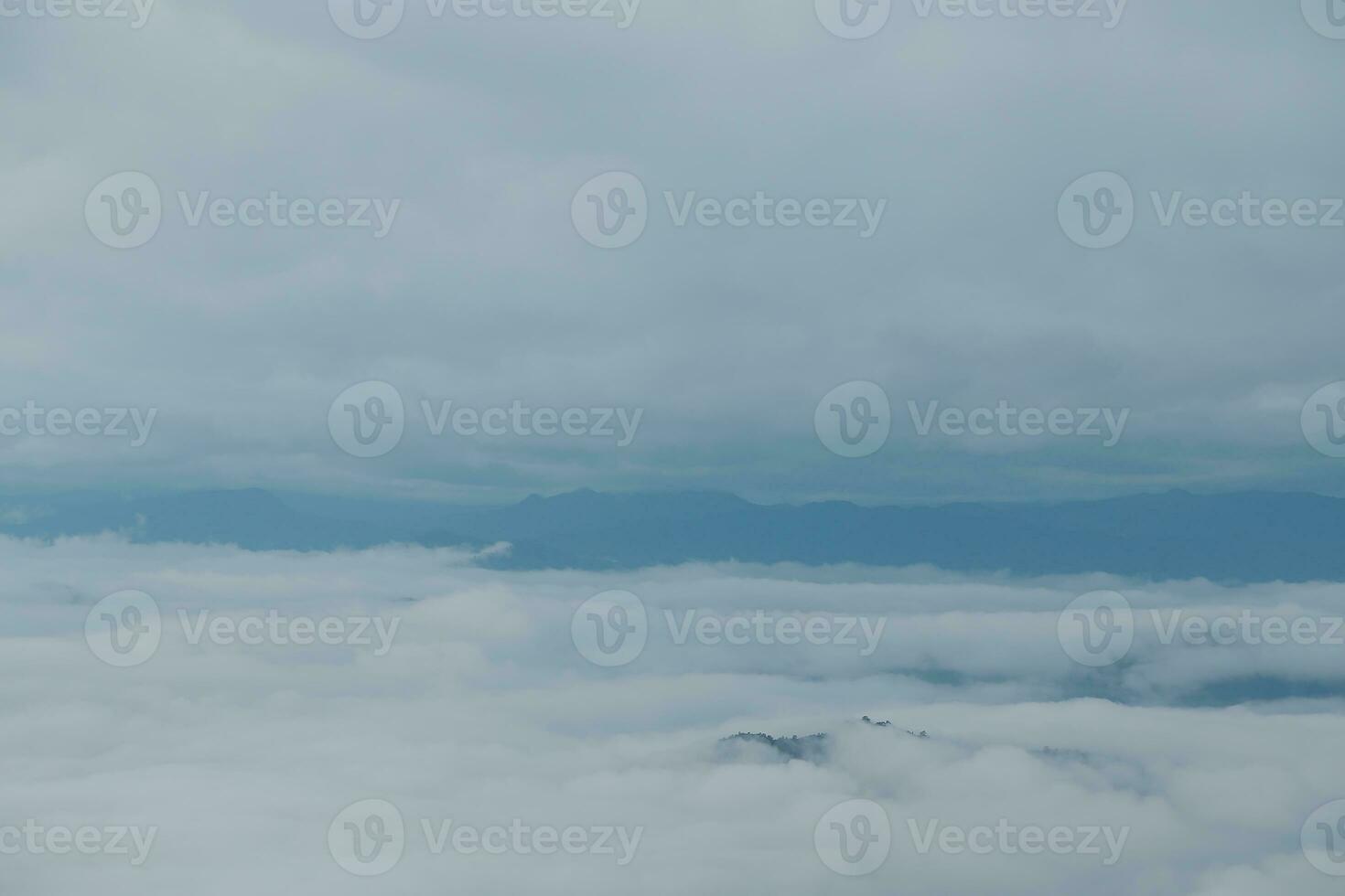 Mountain range with visible silhouettes through the morning blue fog. photo