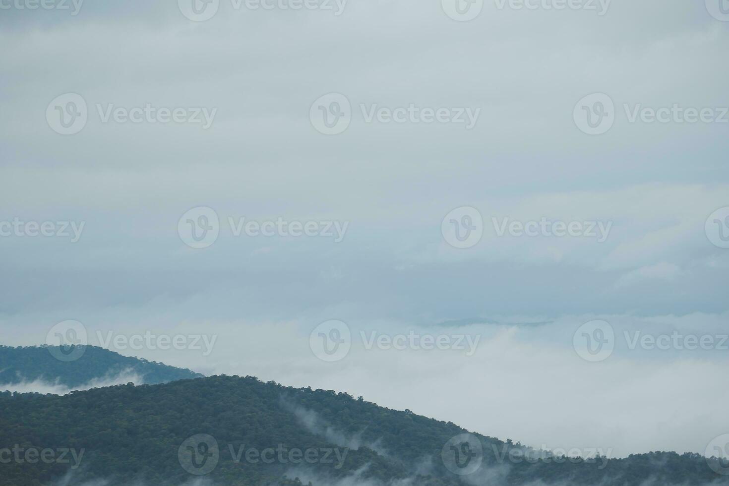 Mountain range with visible silhouettes through the morning blue fog. photo