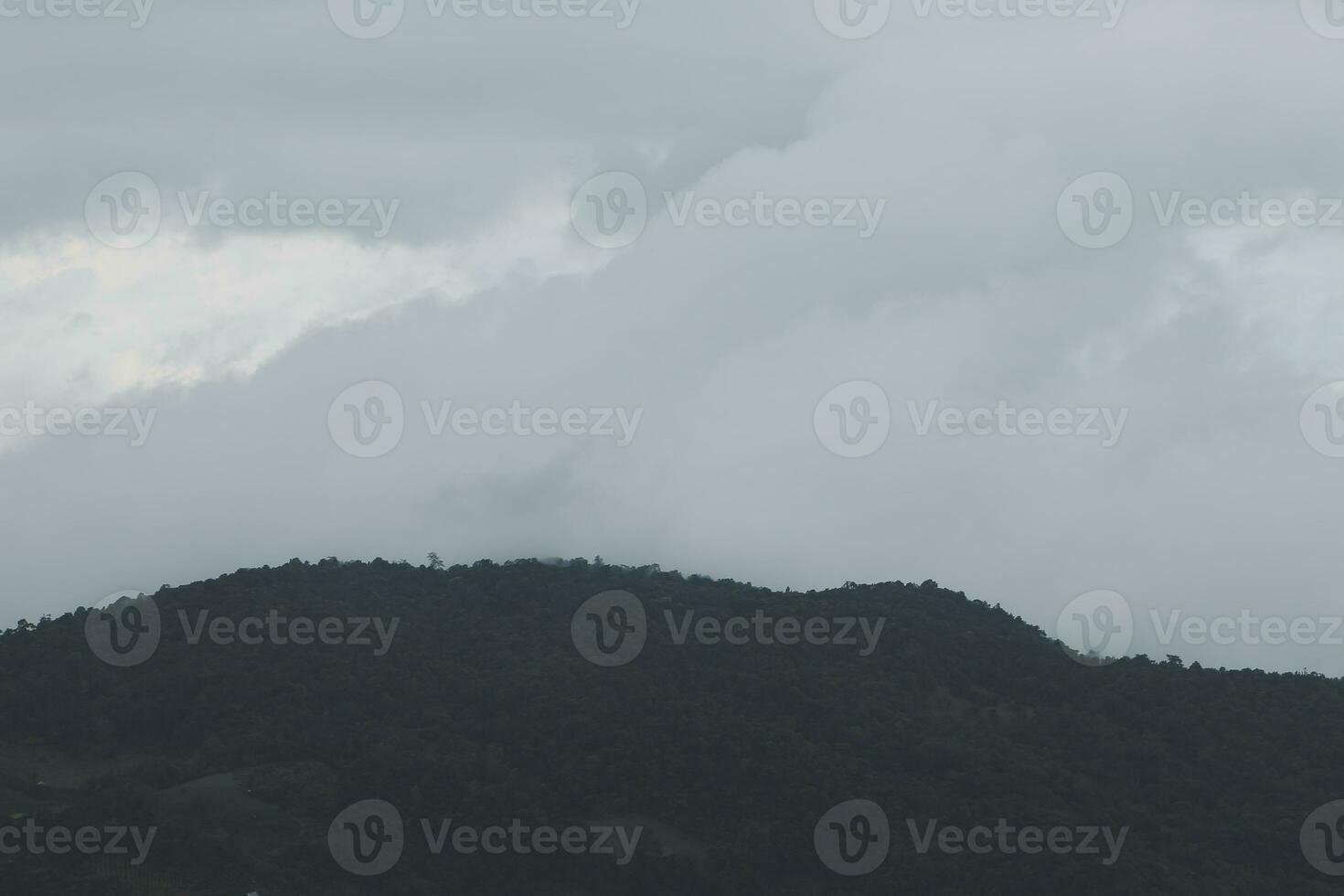 Beautiful panoramic view of fog and clouds in distant layers mountains range with blue sky in morning photo