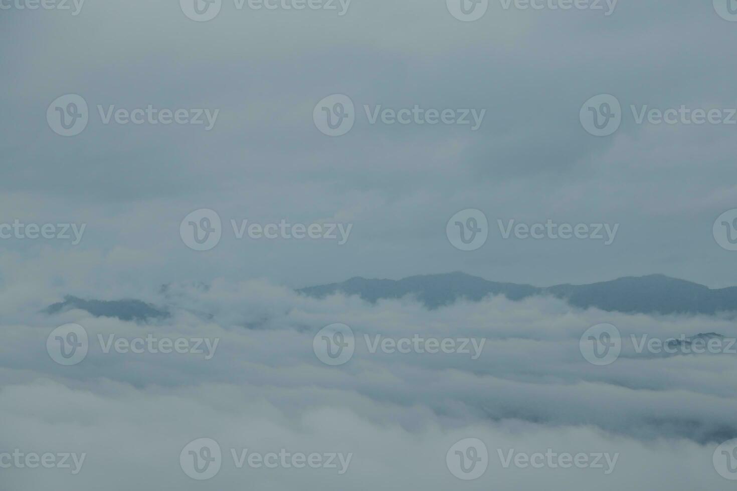 Mountain range with visible silhouettes through the morning blue fog. photo