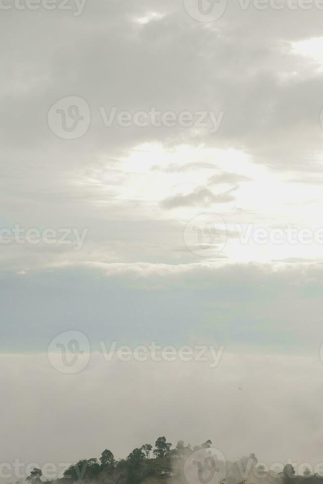 Mountain range with visible silhouettes through the morning blue fog. photo