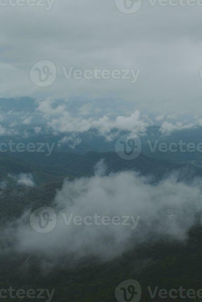 Beautiful panoramic view of fog and clouds in distant layers mountains range with blue sky in morning photo