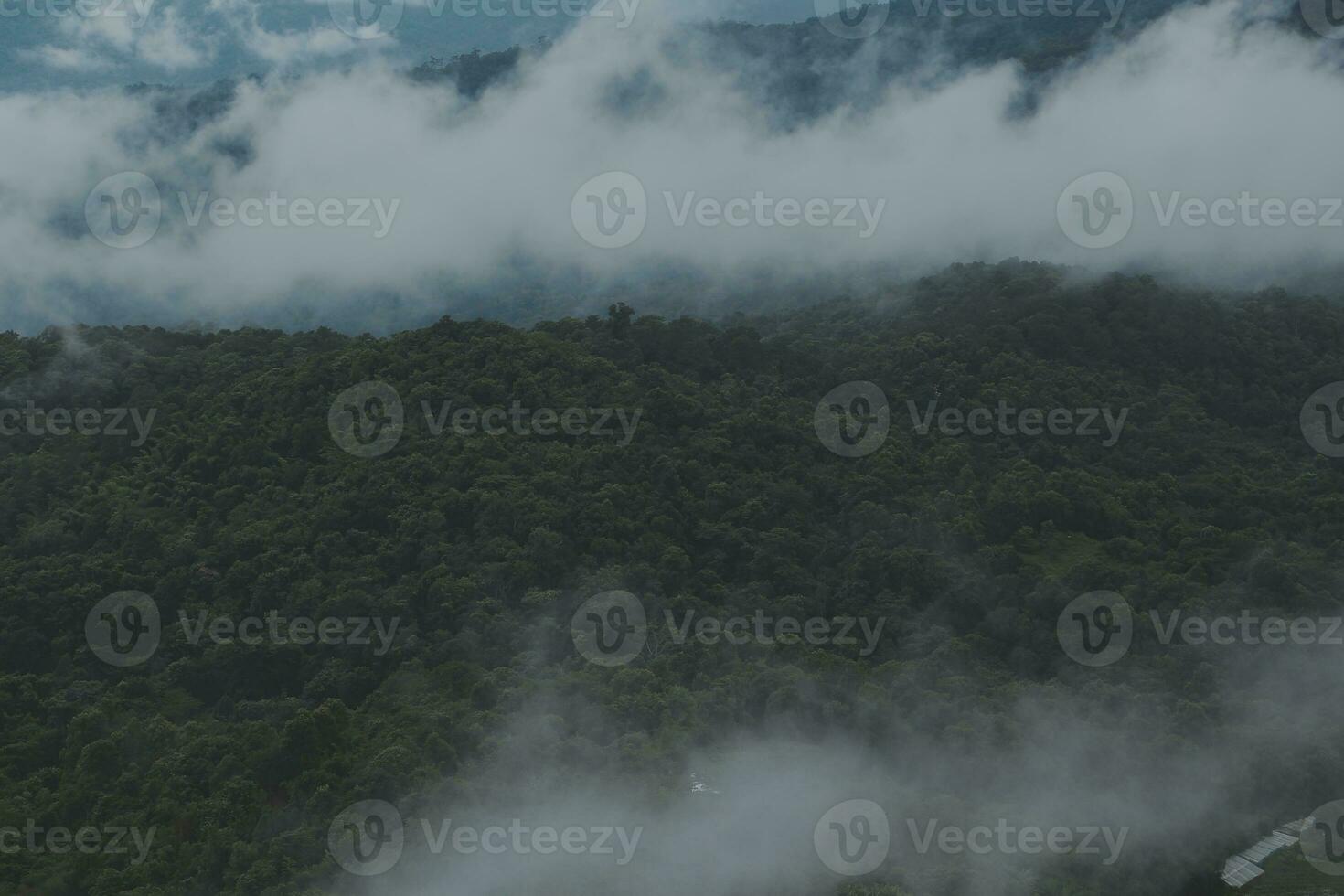 Beautiful panoramic view of fog and clouds in distant layers mountains range with blue sky in morning photo