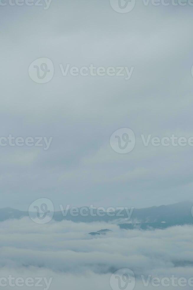 Mountain range with visible silhouettes through the morning blue fog. photo