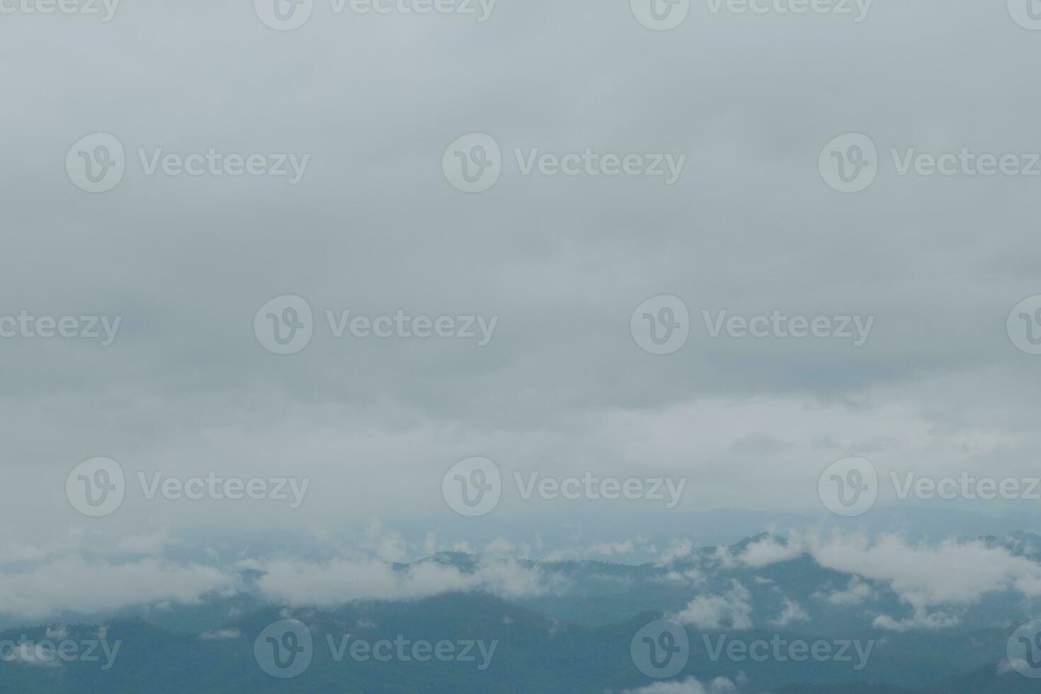 Beautiful panoramic view of fog and clouds in distant layers mountains range with blue sky in morning photo