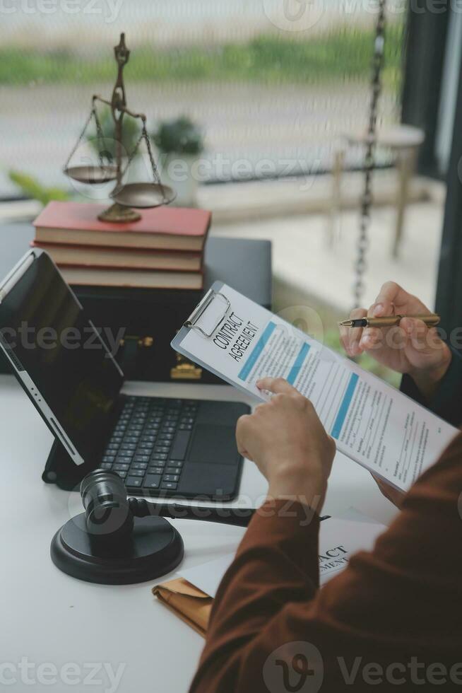 Business and lawyers discussing contract papers with brass scale on desk in office. Law, legal services, advice, justice and law concept picture with film grain effect photo