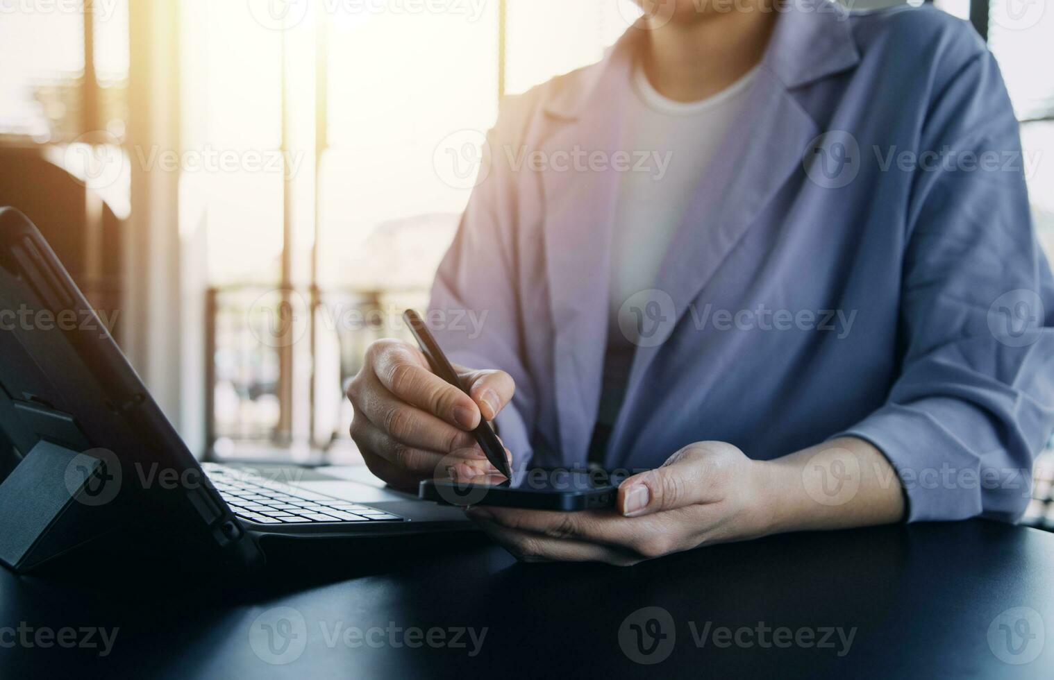 Asian Business woman using calculator and laptop for doing math finance on an office desk, tax, report, accounting, statistics, and analytical research concept photo