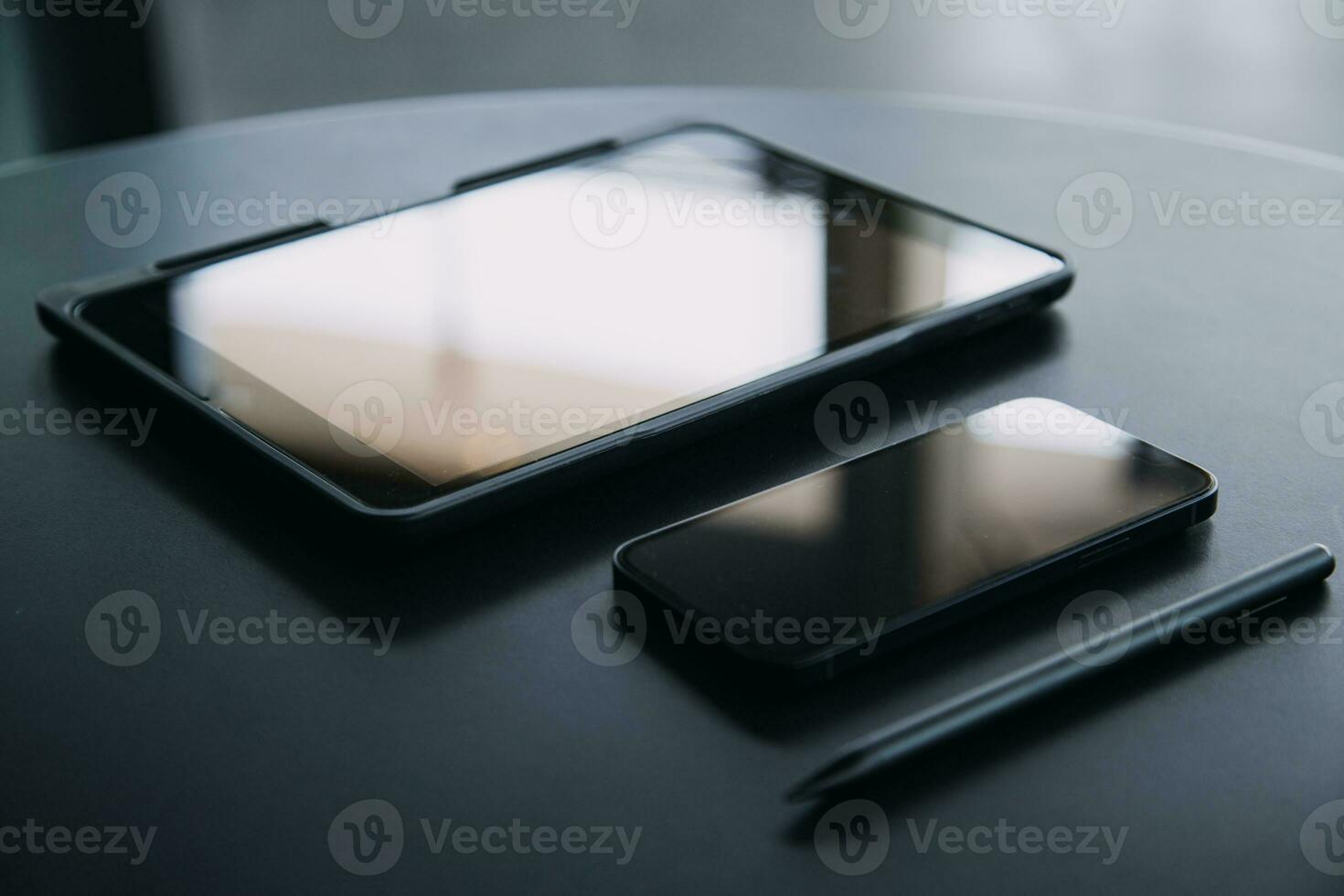 Open laptop with digital tablet and white smartphone. All with isolated screen on old wooden desk. photo