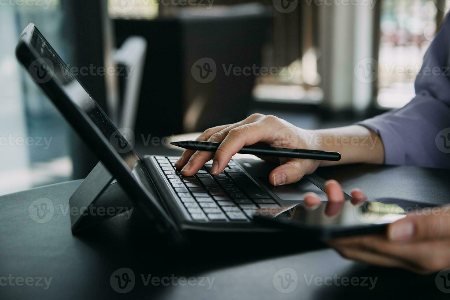 Asian Business woman using calculator and laptop for doing math finance on an office desk, tax, report, accounting, statistics, and analytical research concept photo