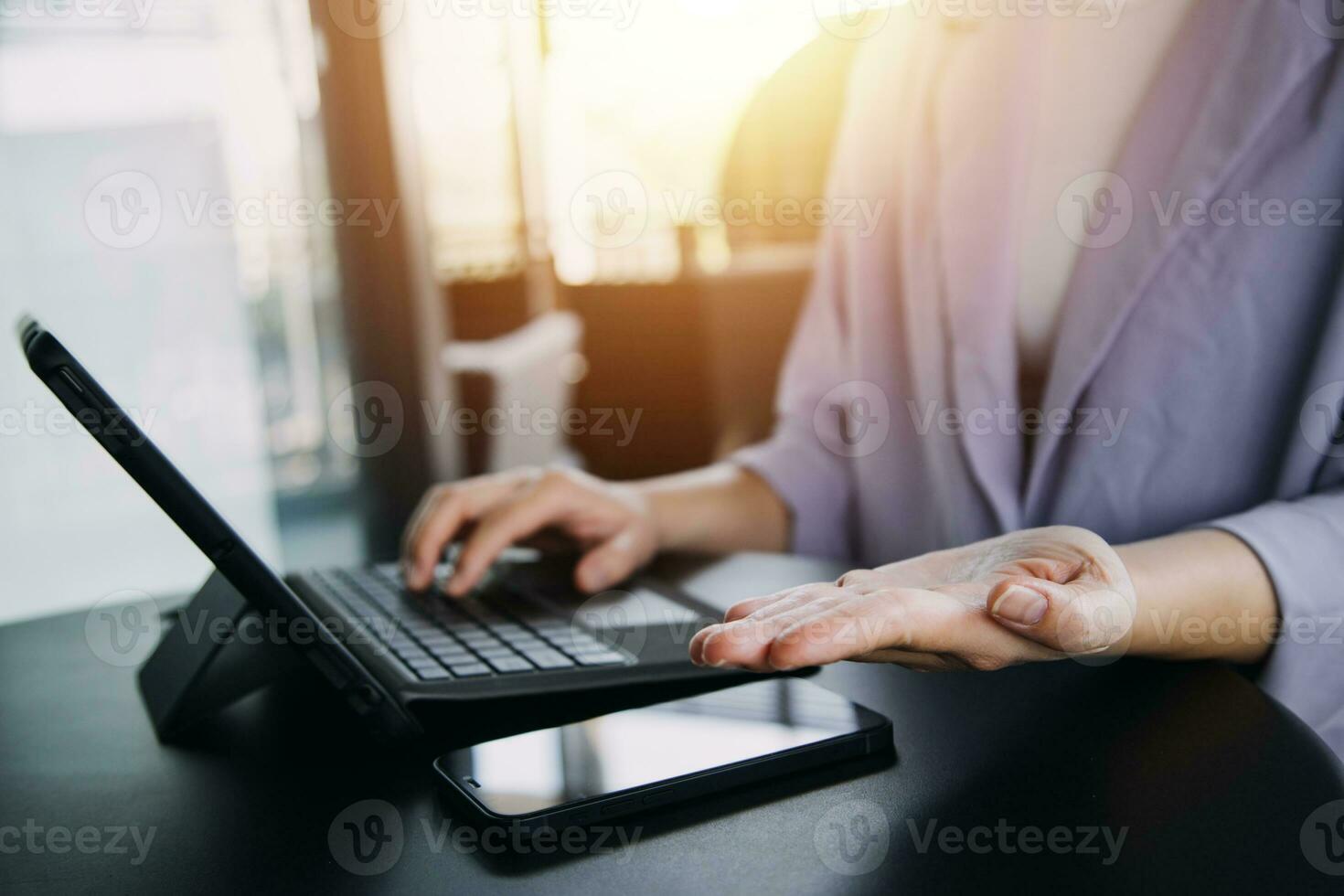 Asian Business woman using calculator and laptop for doing math finance on an office desk, tax, report, accounting, statistics, and analytical research concept photo