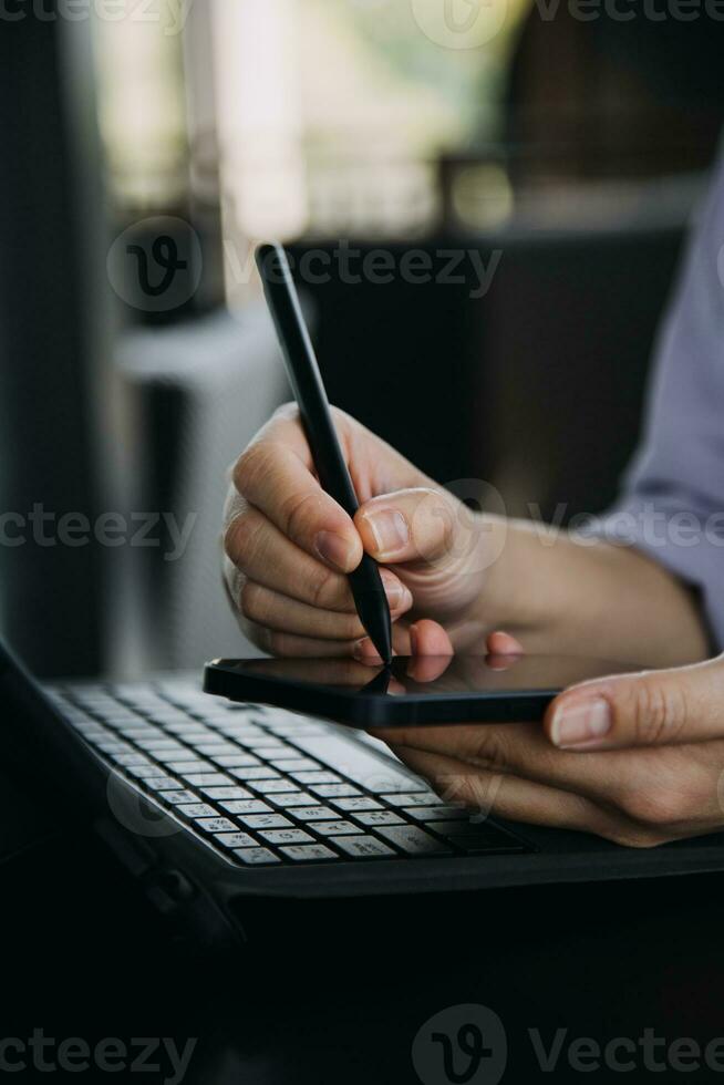 Asian Business woman using calculator and laptop for doing math finance on an office desk, tax, report, accounting, statistics, and analytical research concept photo