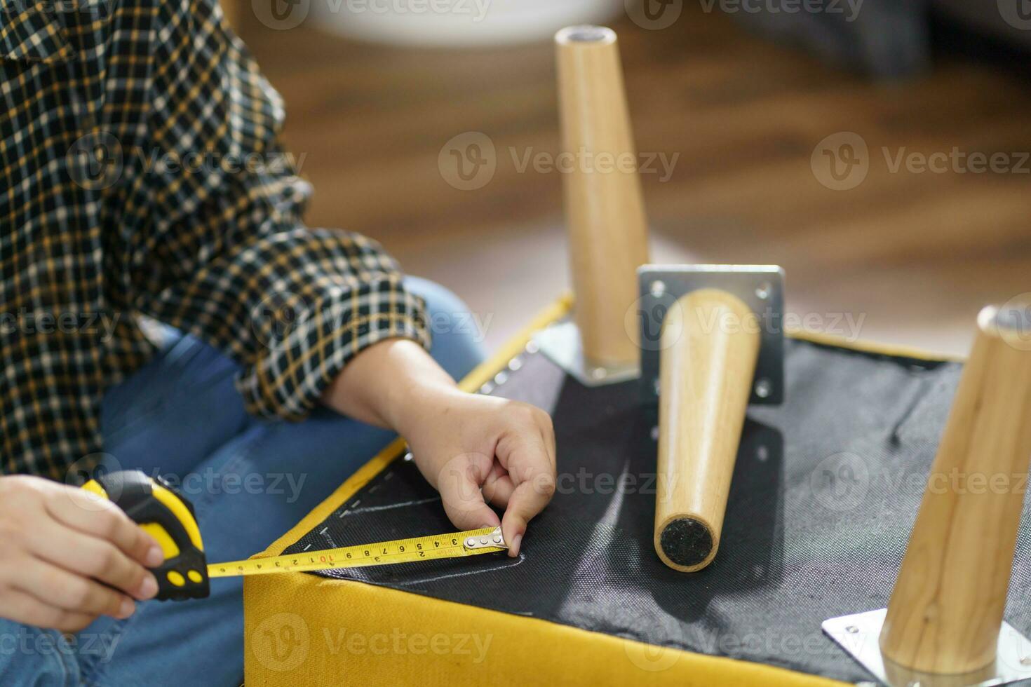 Asian Woman self repairs furniture renovation using equipment to diy repairing furniture sitting on the floor at home photo