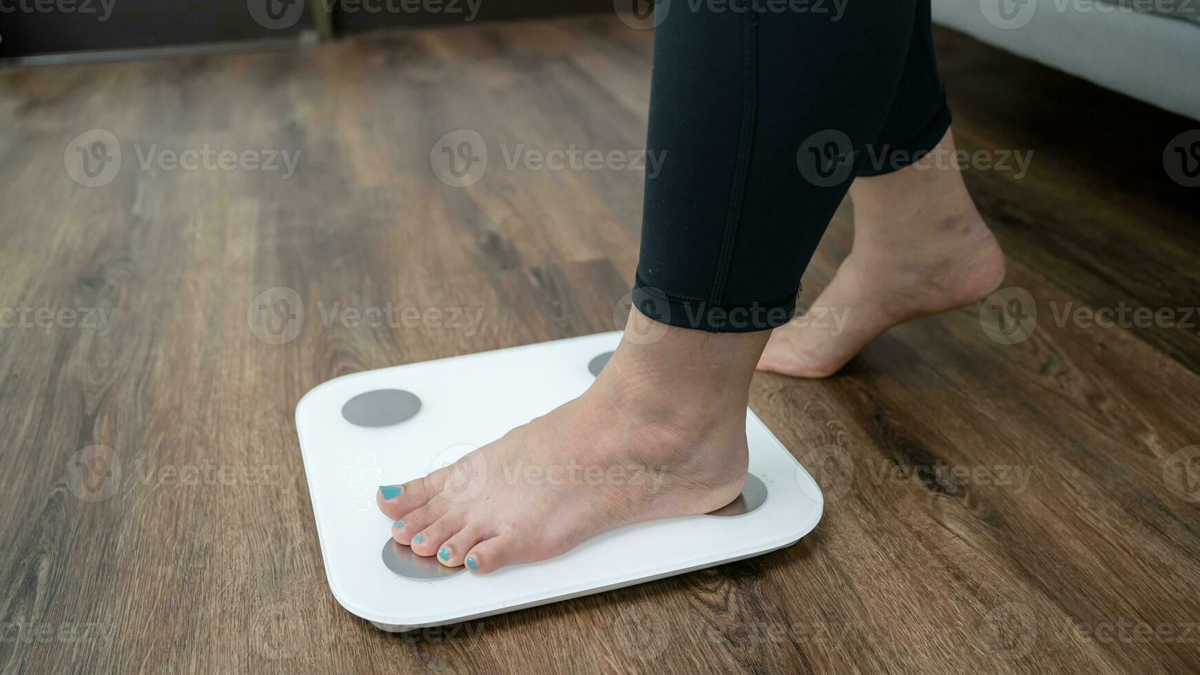 Fat diet and scale feet standing on electronic scales for weight control. Measurement instrument in kilogram for a diet control. photo