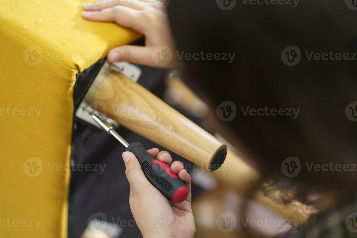 Asian Woman self repairs furniture renovation using equipment to diy repairing furniture sitting on the floor at home photo