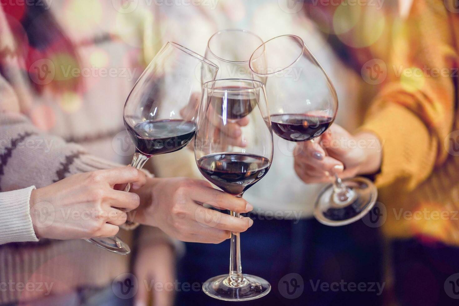 Cheerful friends enjoying home Birthday holiday party. Asian Friends cheering drinking red wine celebrating Christmas or New Year party photo