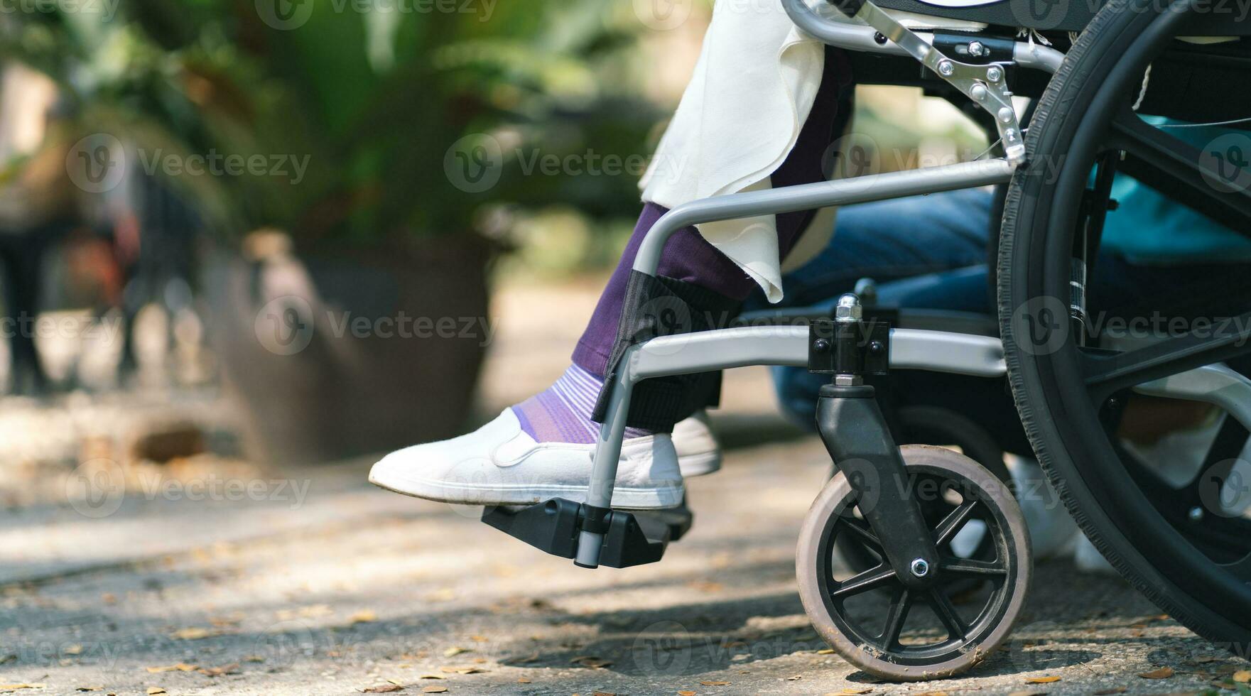 enfermería hogar. joven cuidador Ayudar mayor mujer en silla de ruedas. foto