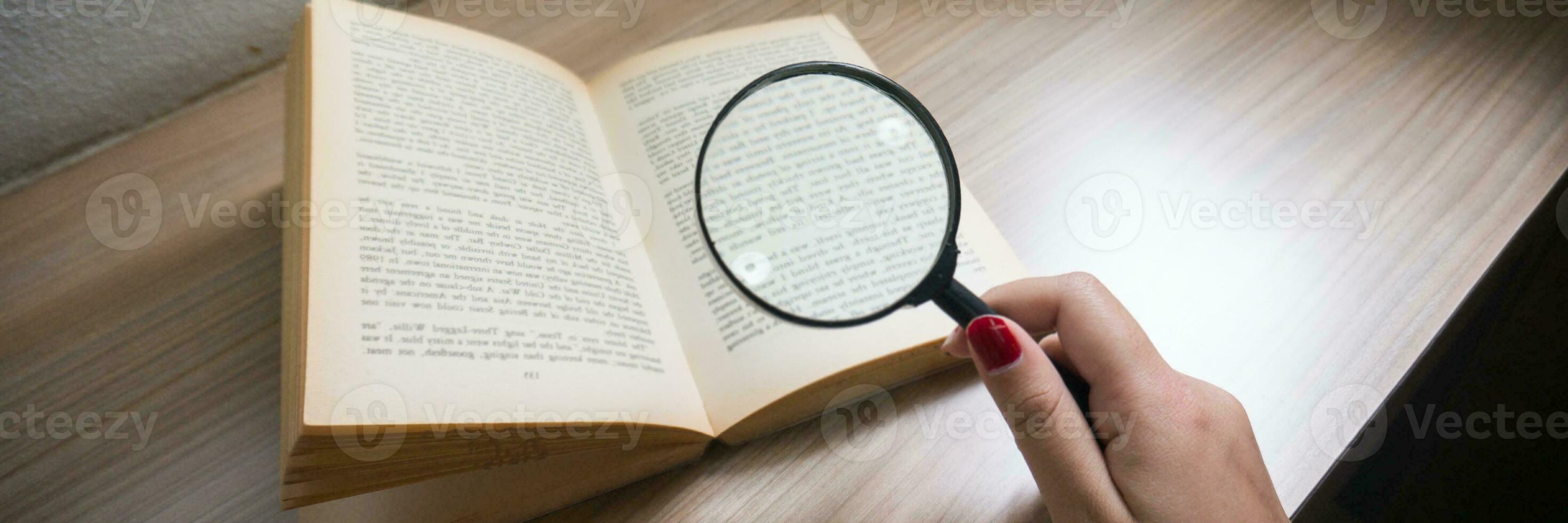 Books and a magnifier Research concept. Magnification glass over a opened book. photo