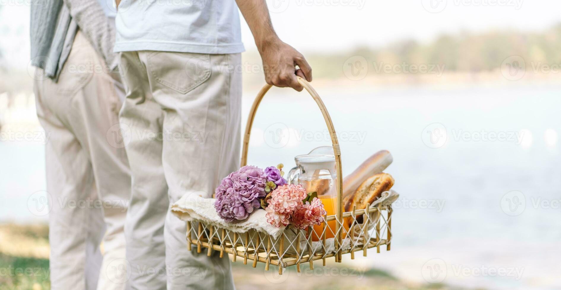 Couple walking in garden with picnic basket. in love couple is enjoying picnic time in park outdoors photo