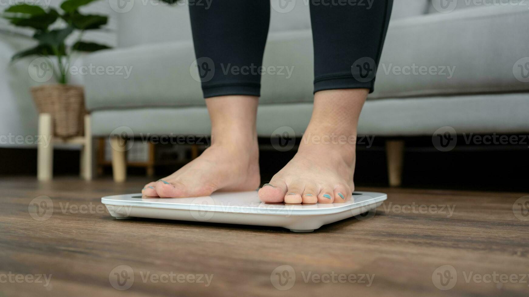 feet standing on electronic scales for weight control. Measurement instrument in kilogram for a diet control photo