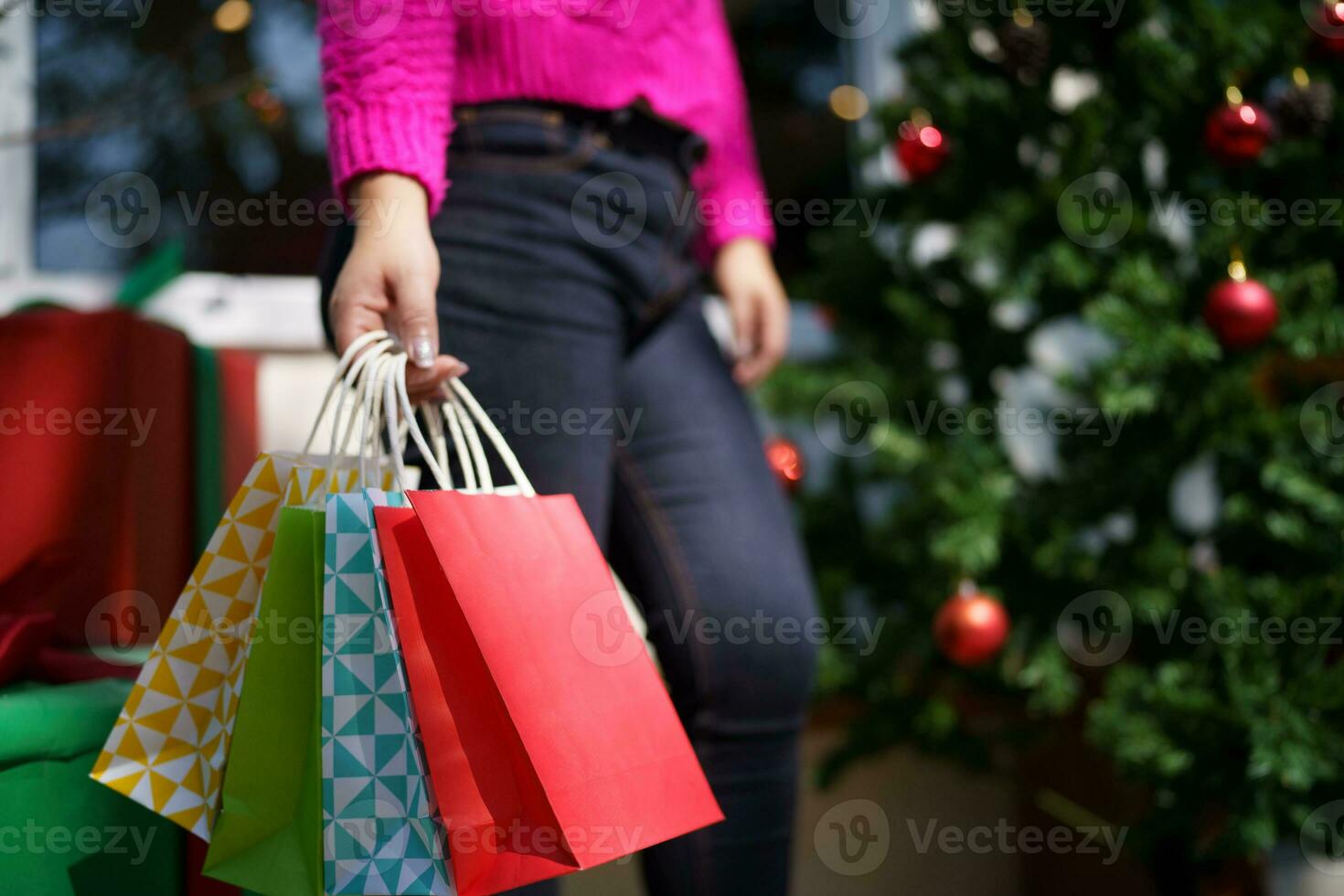 contento asiático niña sostener compras pantalones Navidad presente. alegre mujer con Navidad nuevo año invierno rebaja foto