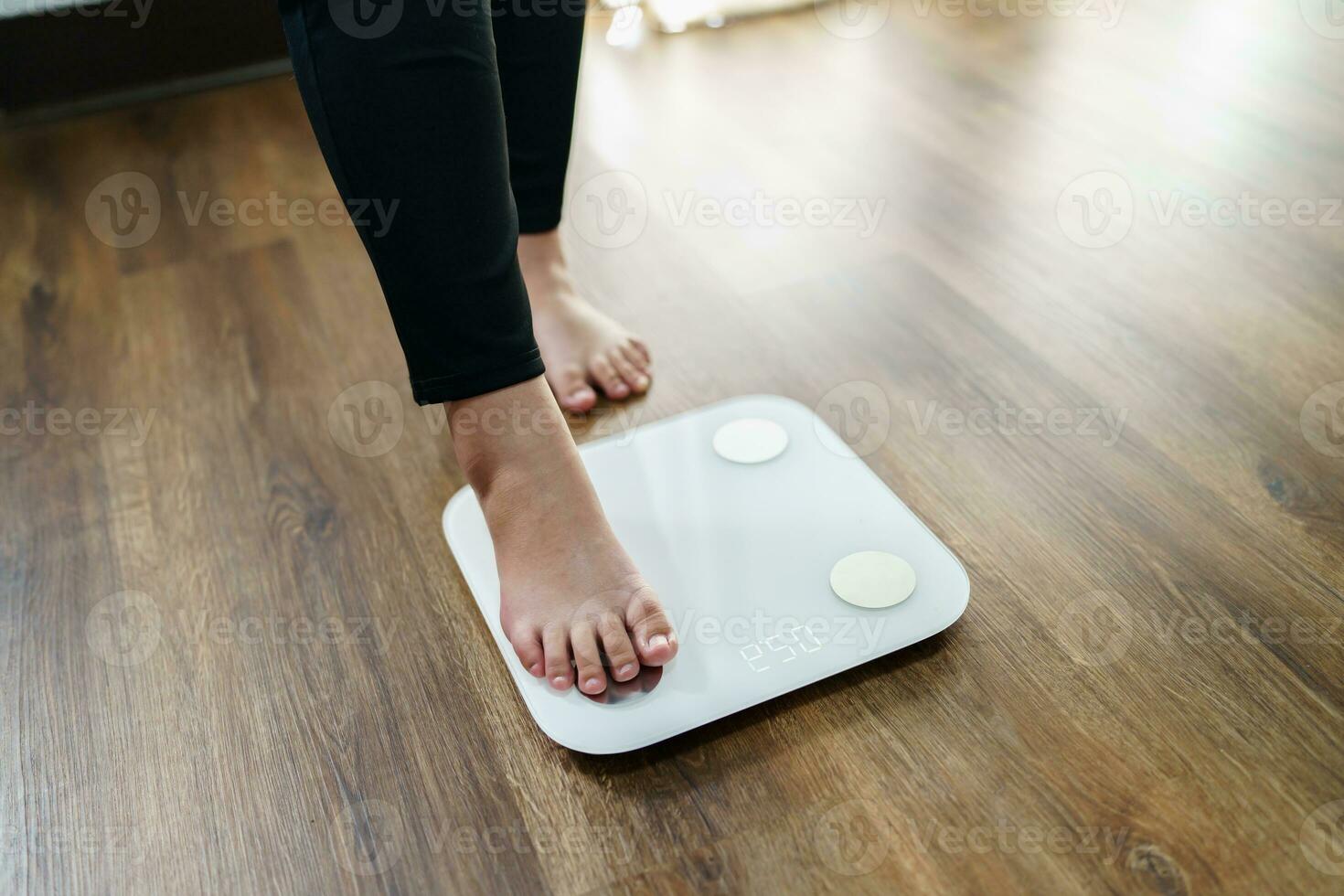 Lose weight. Fat diet and scale feet standing on electronic scales for weight control. Measurement instrument in kilogram for diet. photo