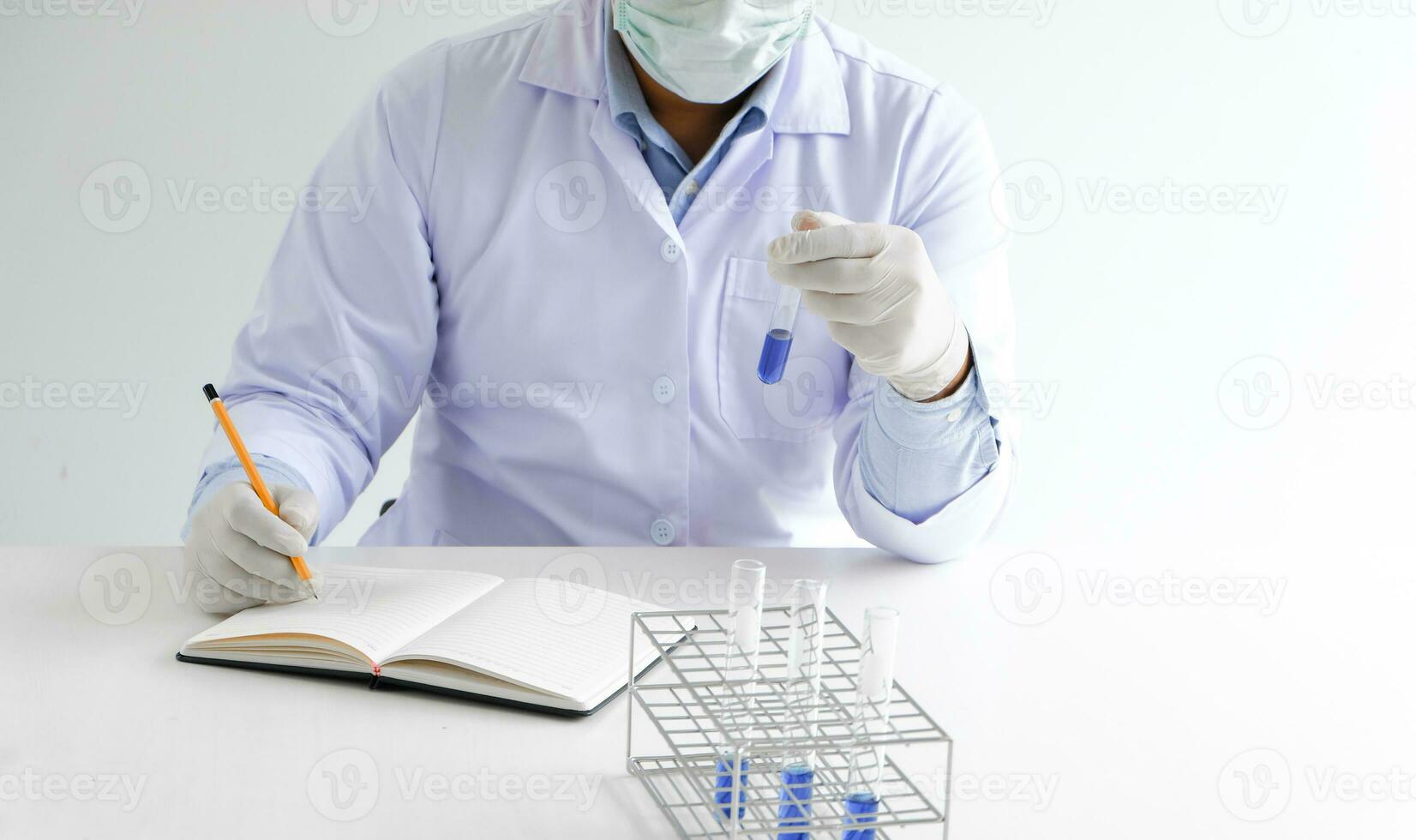 Science innovative Male medical or scientific laboratory researcher performs tests with blue liquid in laboratory. equipment science experiments technology Coronavirus Covid-19 vaccine research photo