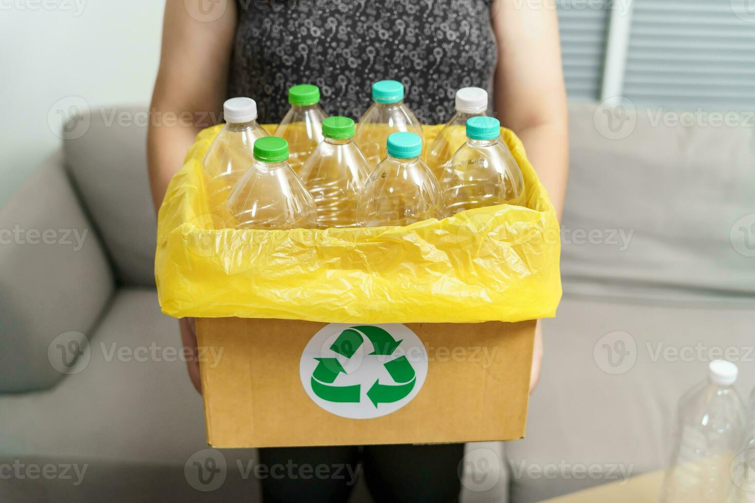 hogar reciclar eco verde cero concepto mujer lanzamiento vacío el plastico botella en reciclaje compartimiento con amarillo basura pantalones a hogar. foto