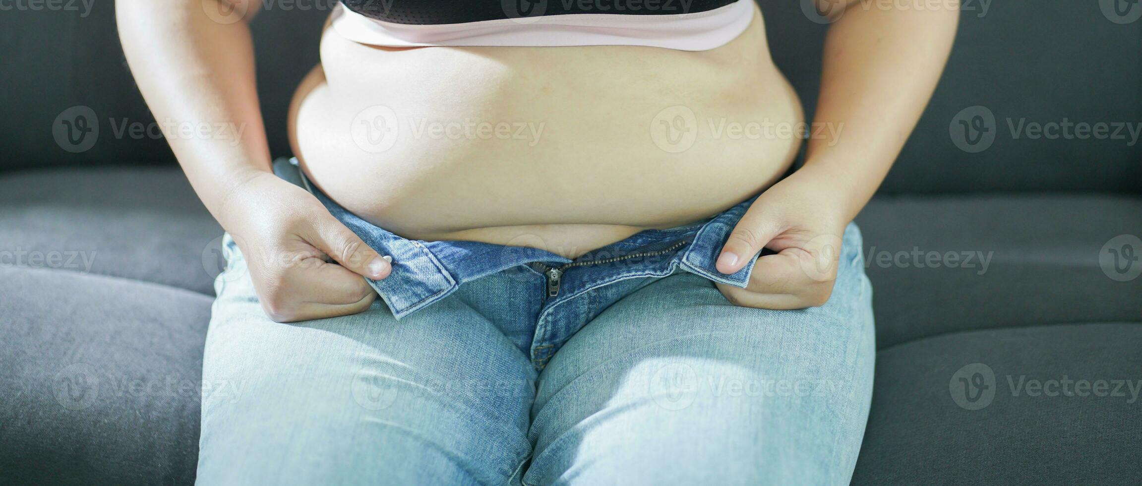 obeso mujer con grasa trastornado acerca de su barriga. exceso de peso mujer conmovedor su grasa barriga y querer a perder peso. grasa mujer con apretado ropa preocupado acerca de peso dieta estilo de vida concepto foto