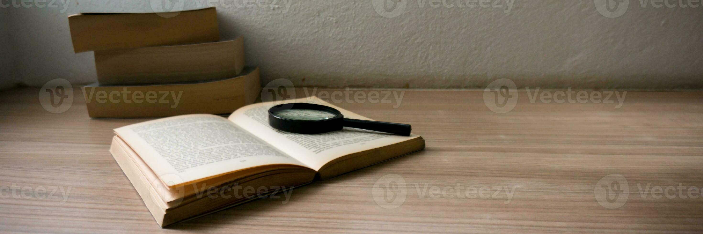 Books and a magnifier Research concept. Magnification glass over a opened book. photo