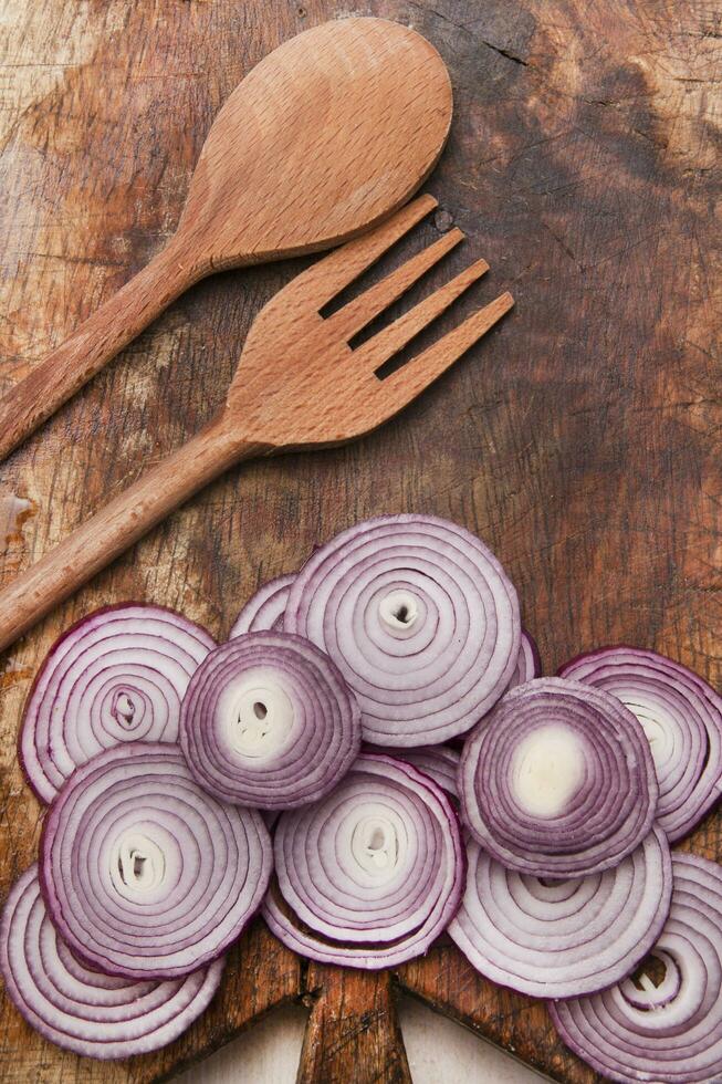 a knife and a bunch of onions on a cutting board photo