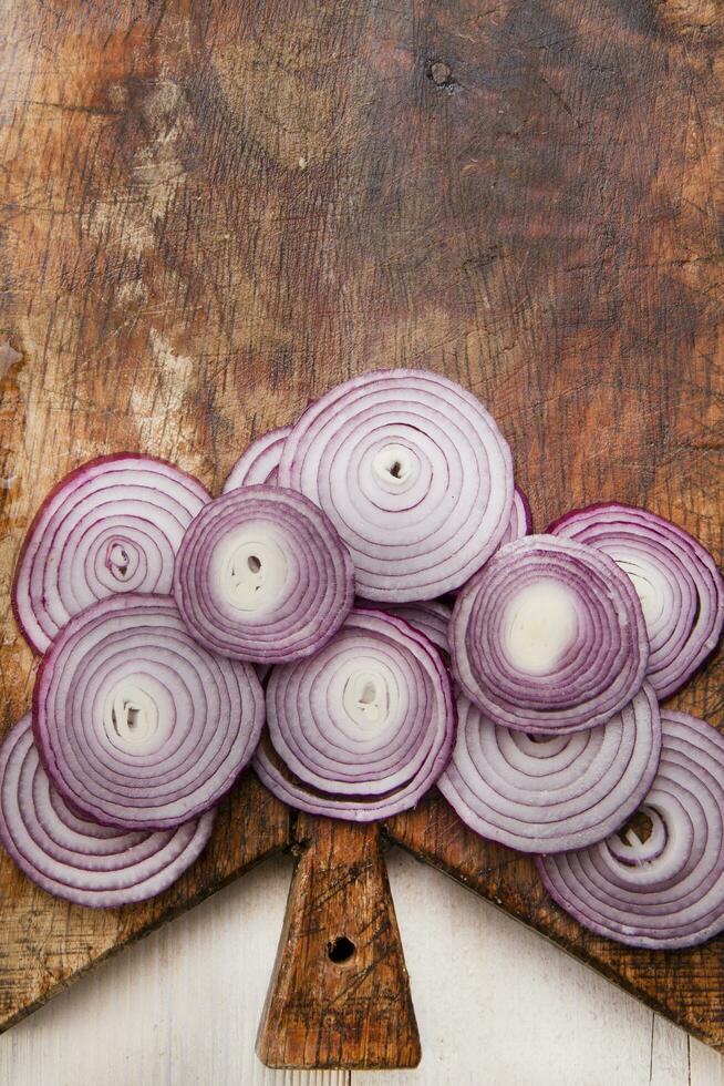 a knife and a bunch of onions on a cutting board photo