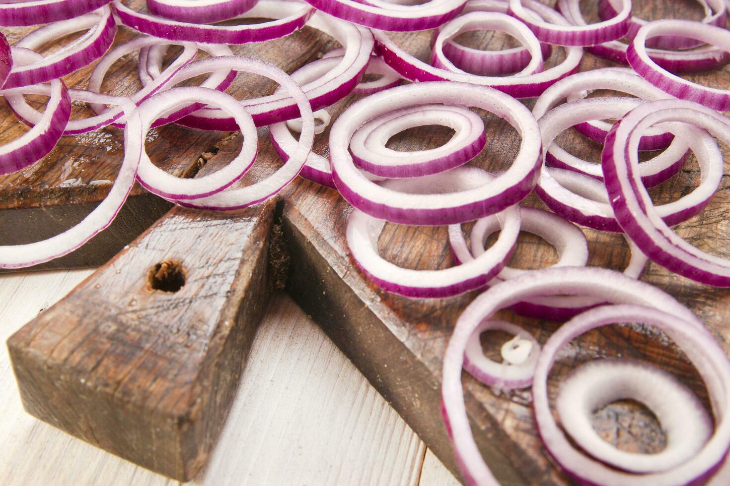 a knife and a bunch of onions on a cutting board photo